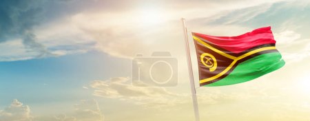 Téléchargez les photos : Vanuatu agitant drapeau dans un ciel magnifique avec soleil - en image libre de droit