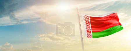 Photo for Belarus waving flag in beautiful sky with sun - Royalty Free Image