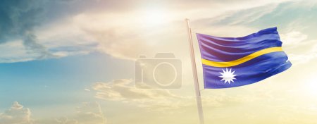 Photo for Nauru waving flag in beautiful sky with sun - Royalty Free Image