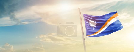 Téléchargez les photos : Drapeau des îles Marshall agitant dans un beau ciel avec le soleil - en image libre de droit
