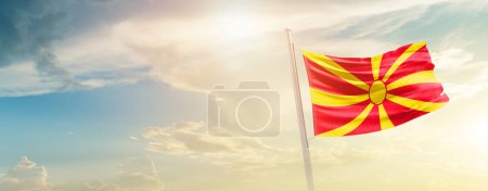 Téléchargez les photos : North Macedonia waving flag in beautiful sky with sun - en image libre de droit
