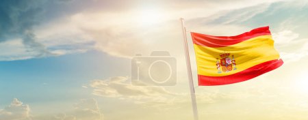 Photo for Spain waving flag in beautiful sky with sun - Royalty Free Image