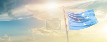Téléchargez les photos : Micronesia waving flag in beautiful sky with sun - en image libre de droit