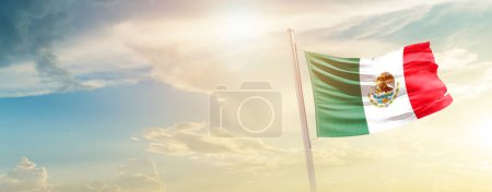 Téléchargez les photos : Mexique agitant le drapeau dans un ciel magnifique avec le soleil - en image libre de droit