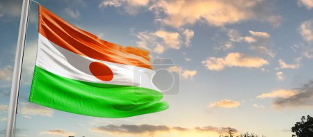 Photo for Niger waving flag in beautiful sky with clouds - Royalty Free Image