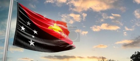 Téléchargez les photos : Papouasie-Nouvelle-Guinée agitant le drapeau dans un ciel magnifique avec des nuages - en image libre de droit