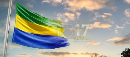 Gabon waving flag in beautiful sky with clouds