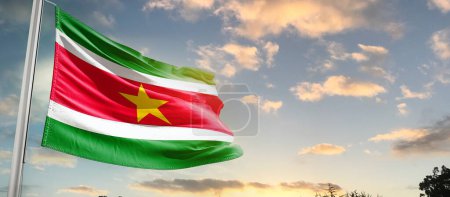 Photo for Suriname waving flag in beautiful sky with clouds - Royalty Free Image