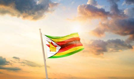 Foto de Zimbabue ondeando bandera en el hermoso cielo con nubes y sol - Imagen libre de derechos