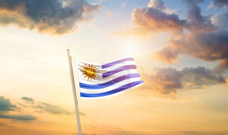 Foto de Uruguay ondeando bandera en hermoso cielo con nubes y sol - Imagen libre de derechos