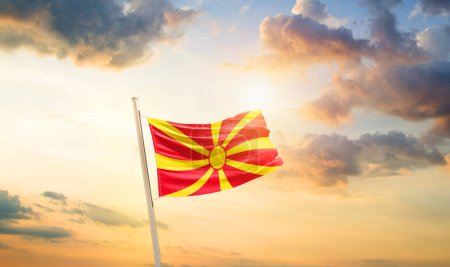 Foto de Macedonia del Norte ondeando bandera en hermoso cielo con nubes y sol - Imagen libre de derechos