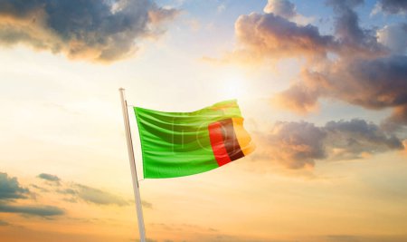 Foto de Zambia ondeando bandera en hermoso cielo con nubes y sol - Imagen libre de derechos
