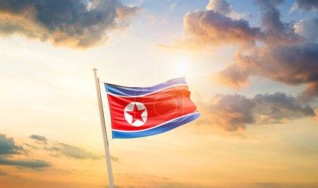 Foto de Corea del Norte ondeando bandera en el hermoso cielo con nubes y sol - Imagen libre de derechos