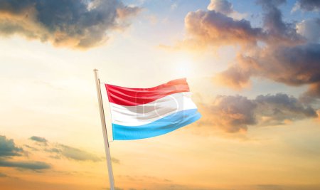 Foto de Luxemburgo ondeando bandera en el hermoso cielo con nubes y sol - Imagen libre de derechos