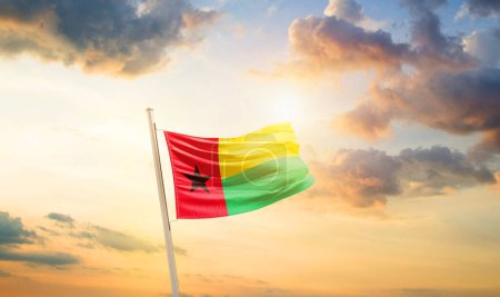 Téléchargez les photos : Drapeau de Guinée-Bissau dans un ciel magnifique avec nuages et soleil - en image libre de droit
