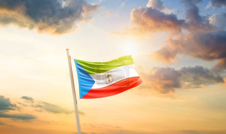 Foto de Guinea Ecuatorial ondeando bandera en hermoso cielo con nubes y sol - Imagen libre de derechos