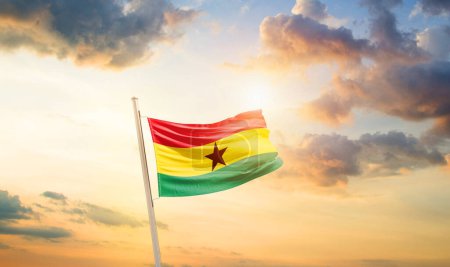 Foto de Ghana ondeando bandera en el hermoso cielo con nubes y sol - Imagen libre de derechos