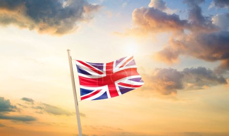 Téléchargez les photos : Royaume-Uni agitant le drapeau dans un ciel magnifique avec des nuages et du soleil - en image libre de droit