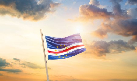 Téléchargez les photos : Pavillon du Cap Vert agitant le drapeau dans un ciel magnifique avec nuages et soleil - en image libre de droit