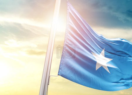 Téléchargez les photos : Drapeau de Somalie contre ciel avec soleil - en image libre de droit