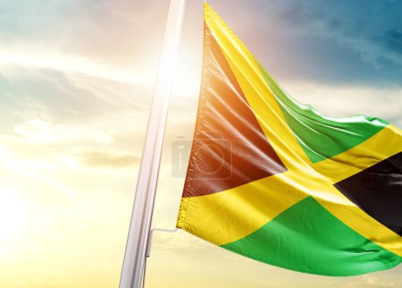 Téléchargez les photos : Drapeau de la Jamaïque contre le ciel avec soleil - en image libre de droit