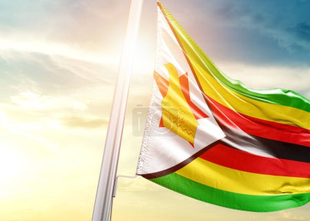 Téléchargez les photos : Drapeau du Zimbabwe contre le ciel avec soleil - en image libre de droit