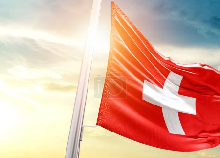 Foto de Suiza bandera contra el cielo con sol - Imagen libre de derechos