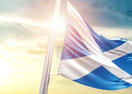 Téléchargez les photos : Drapeau d'Écosse contre ciel avec soleil - en image libre de droit