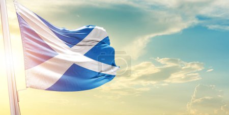 Foto de Bandera de Escocia contra el cielo con nubes y sol - Imagen libre de derechos