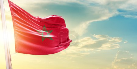 Foto de Bandera de Marruecos contra el cielo con nubes y sol - Imagen libre de derechos