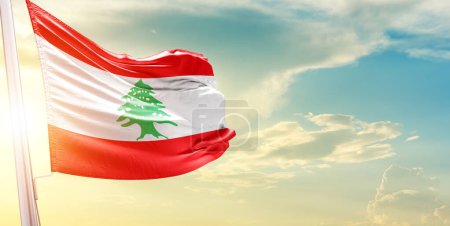 Lebanon flag against sky with clouds and sun