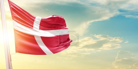 Foto de Bandera de Dinamarca contra el cielo con nubes y sol - Imagen libre de derechos