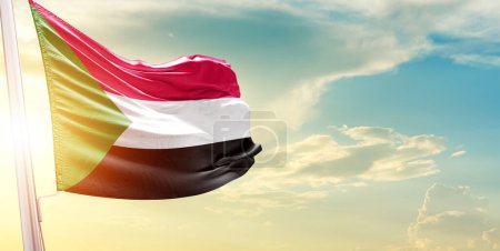 Foto de Bandera de Sudán contra el cielo con nubes y sol - Imagen libre de derechos