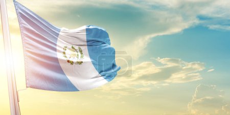 Foto de Bandera de Guatemala contra el cielo con nubes y sol - Imagen libre de derechos