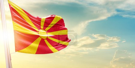 Téléchargez les photos : Drapeau de Macédoine du Nord contre le ciel avec nuages et soleil - en image libre de droit