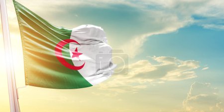 Téléchargez les photos : Drapeau Algérie contre ciel avec nuages et soleil - en image libre de droit