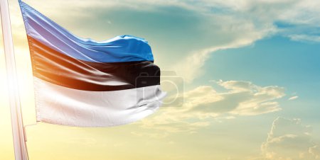Téléchargez les photos : Estonie drapeau contre ciel avec nuages et soleil - en image libre de droit
