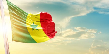 Téléchargez les photos : Drapeau Sénégal contre ciel avec nuages et soleil - en image libre de droit