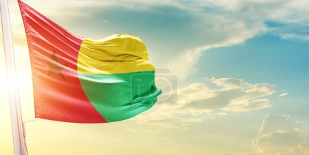 Téléchargez les photos : Drapeau Guinée-Bissau contre le ciel avec nuages et soleil - en image libre de droit