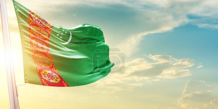 Téléchargez les photos : Drapeau du Turkménistan contre le ciel avec nuages et soleil - en image libre de droit
