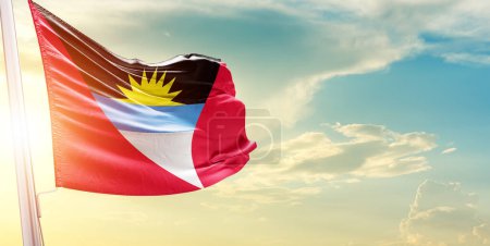 Photo for Antigua and Barbuda flag against sky with clouds and sun - Royalty Free Image