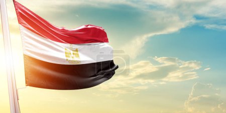 Foto de Bandera de Egipto contra el cielo con nubes y sol - Imagen libre de derechos