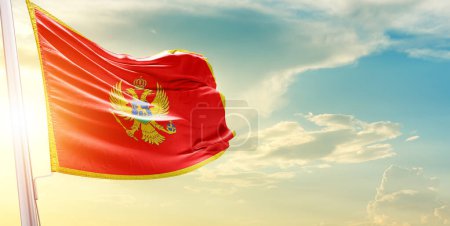 Foto de Montenegro bandera contra el cielo con nubes y sol - Imagen libre de derechos