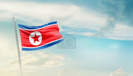 Téléchargez les photos : Corée du Nord agitant drapeau contre ciel bleu avec des nuages - en image libre de droit