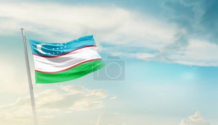 Uzbekistán ondeando bandera contra el cielo azul con nubes