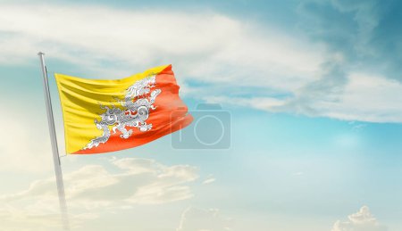 Bután ondeando bandera contra el cielo azul con nubes