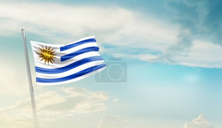 Téléchargez les photos : Uruguay agitant drapeau contre ciel bleu avec des nuages - en image libre de droit