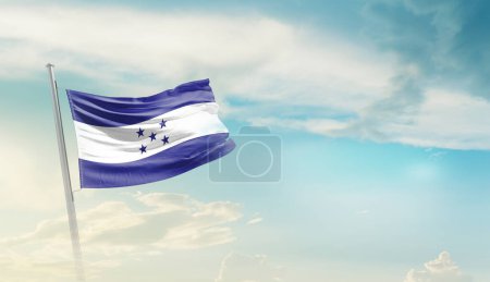 Honduras ondeando bandera contra cielo azul con nubes