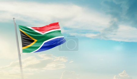 Foto de Sudáfrica ondeando bandera contra el cielo azul con nubes - Imagen libre de derechos