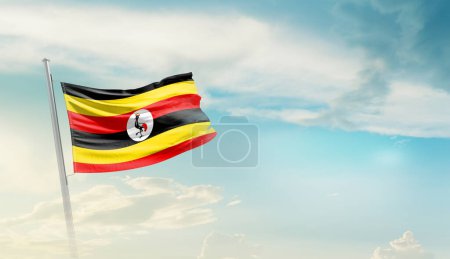 Uganda ondeando bandera contra el cielo azul con nubes